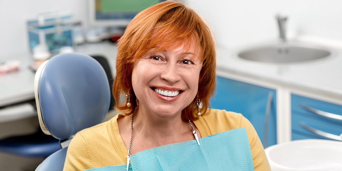 пациентка улыбается после протезирования зубов